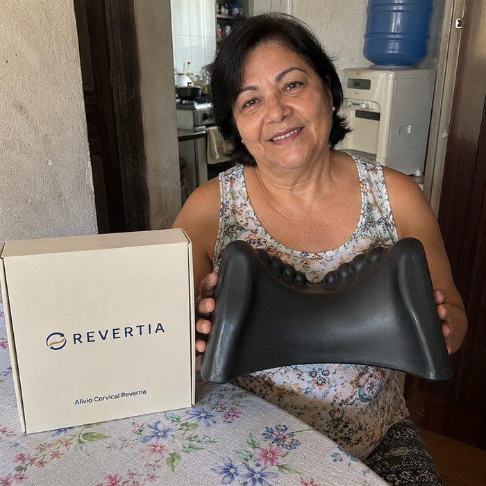 Vera Lucia sorrindo, segurando o Alívio Cervical Revertia
